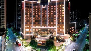 Un hotel de varios pisos con un atrio central y una terraza en la azotea.