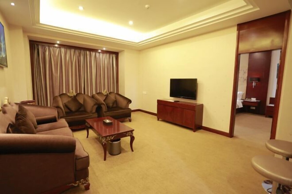 A living room with a sofa, a coffee table, a TV, and a cabinet.