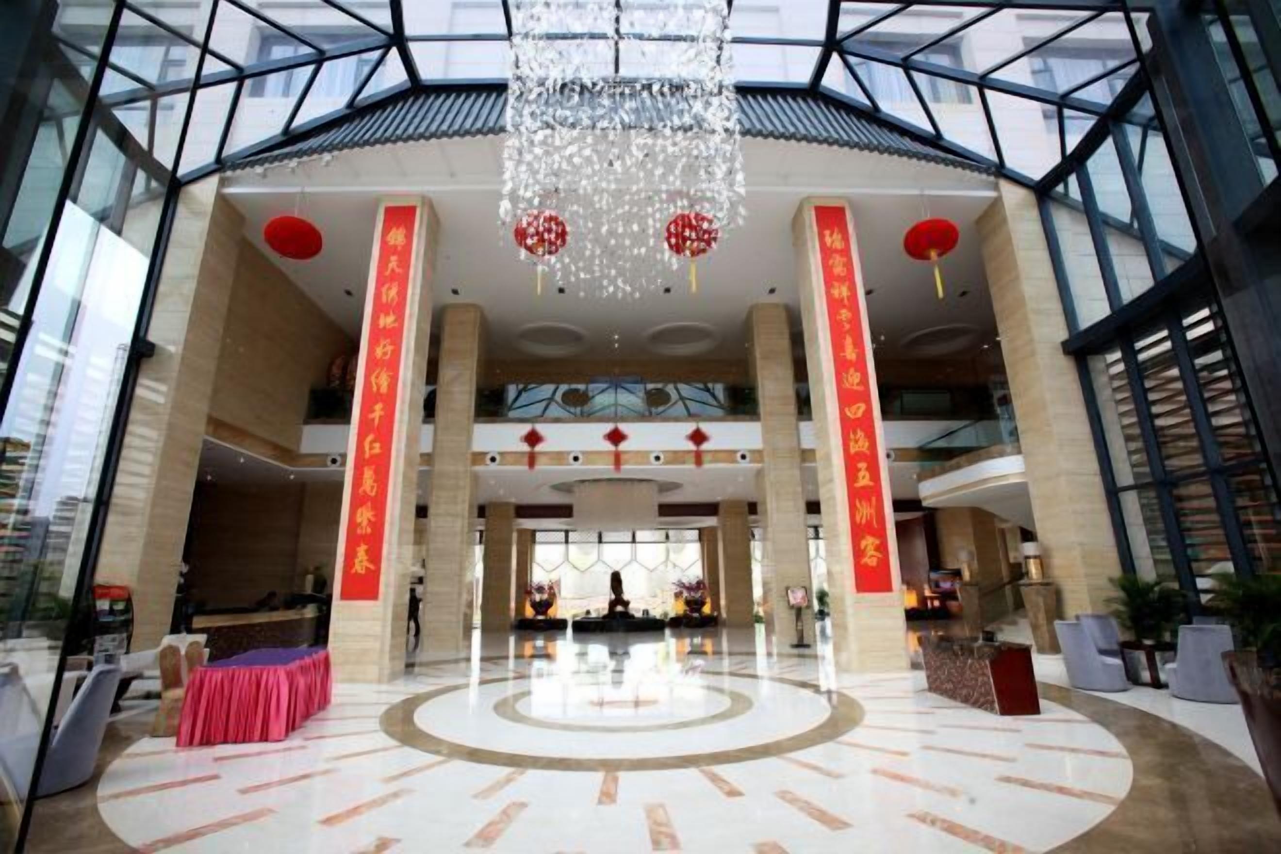 A spacious lobby with a high ceiling, large windows, and a central seating area.