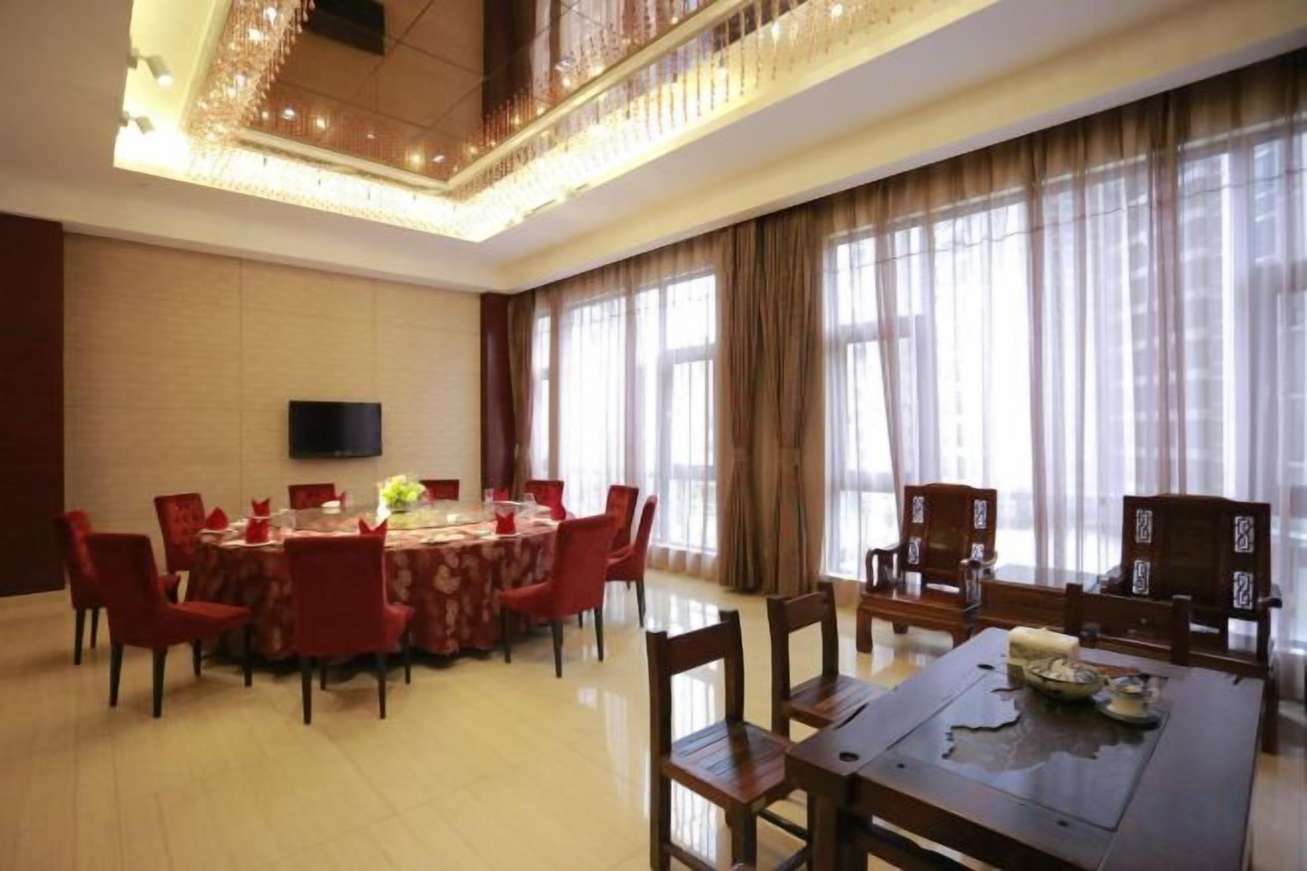 A conference room with a round table, chairs, and a television screen.
