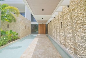 A modern hallway with a stone wall on one side and a glass door at the end.