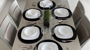 A modern dining table set for six with black and white plates, silverware, and clear glasses. - Penthouse in front of Estrella de Puebla 16 guest (Heroica Puebla de Zaragoza)