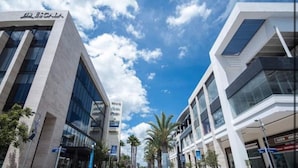 Un edificio moderno con fachada de vidrio y un letrero que dice "La Escala".