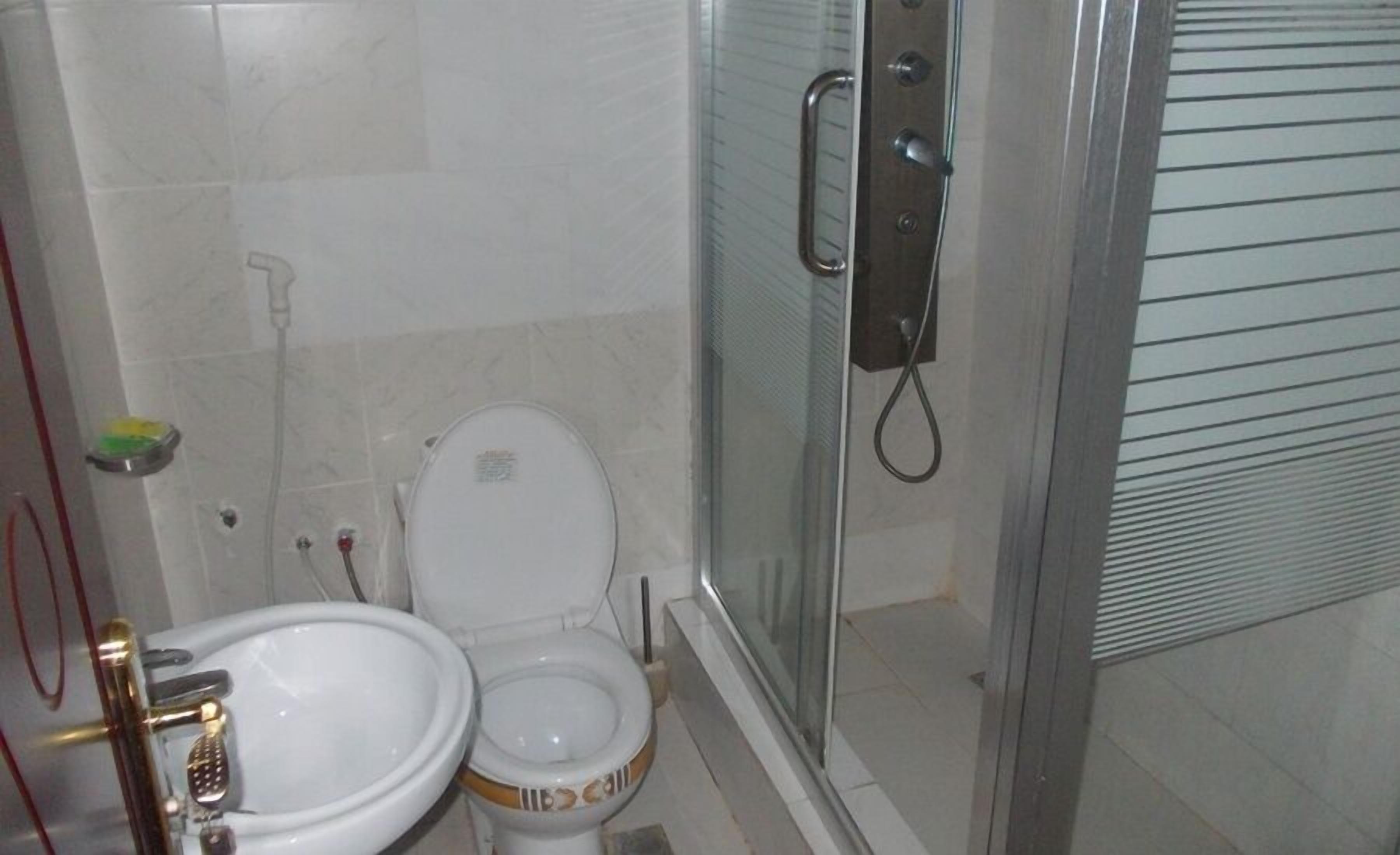 Ein Badezimmer mit Toilette, Waschbecken und Dusche.