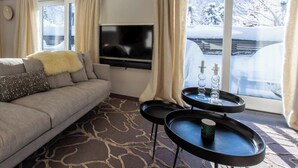 Una sala de estar moderna con un sofá, un televisor de pantalla plana y una mesa de centro.