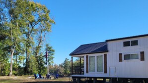 Een stacaravan met een veranda, grote ramen en een terras.