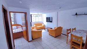 Une pièce comprenant un lit, deux canapés, un téléviseur et une table à manger.