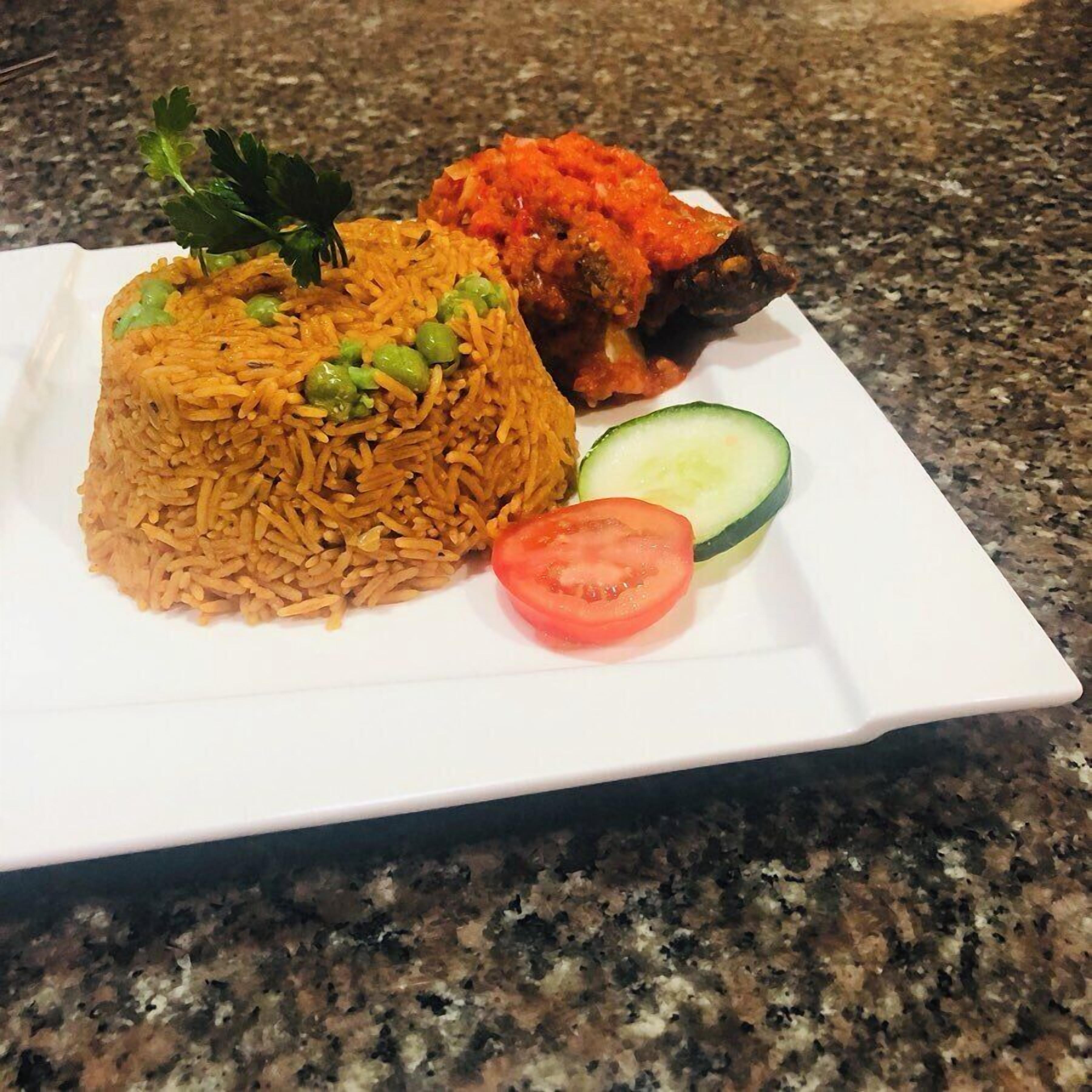 A plate of rice with peas, a slice of tomato, and a cucumber on a granite countertop.
