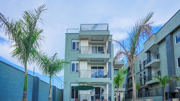 Un edificio moderno con varios balcones y una zona de piscina.