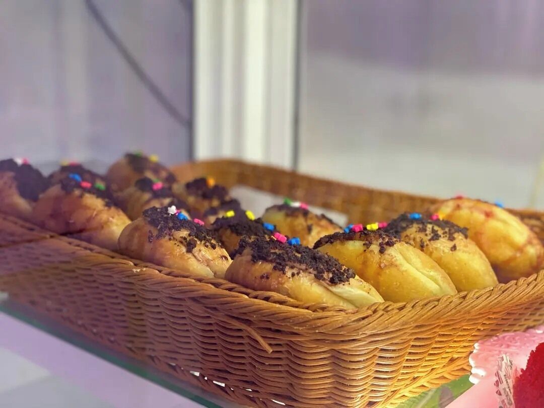 Una vitrina con pasteles en una cesta de mimbre.