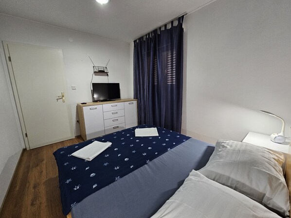 A bedroom with a bed, a desk with a television, a lamp, and a window with curtains. - Modern apartment Nikola in a quiet area (Kastela)