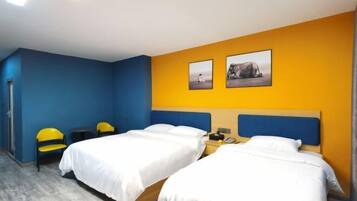 Een hotelkamer met twee bedden, een nachtkastje, een stoel en kunst aan de muur.