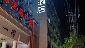 Un letrero de hotel con caracteres chinos y fachada de edificio con andamios.