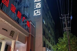 Un letrero de hotel con caracteres chinos y fachada de edificio con andamios.