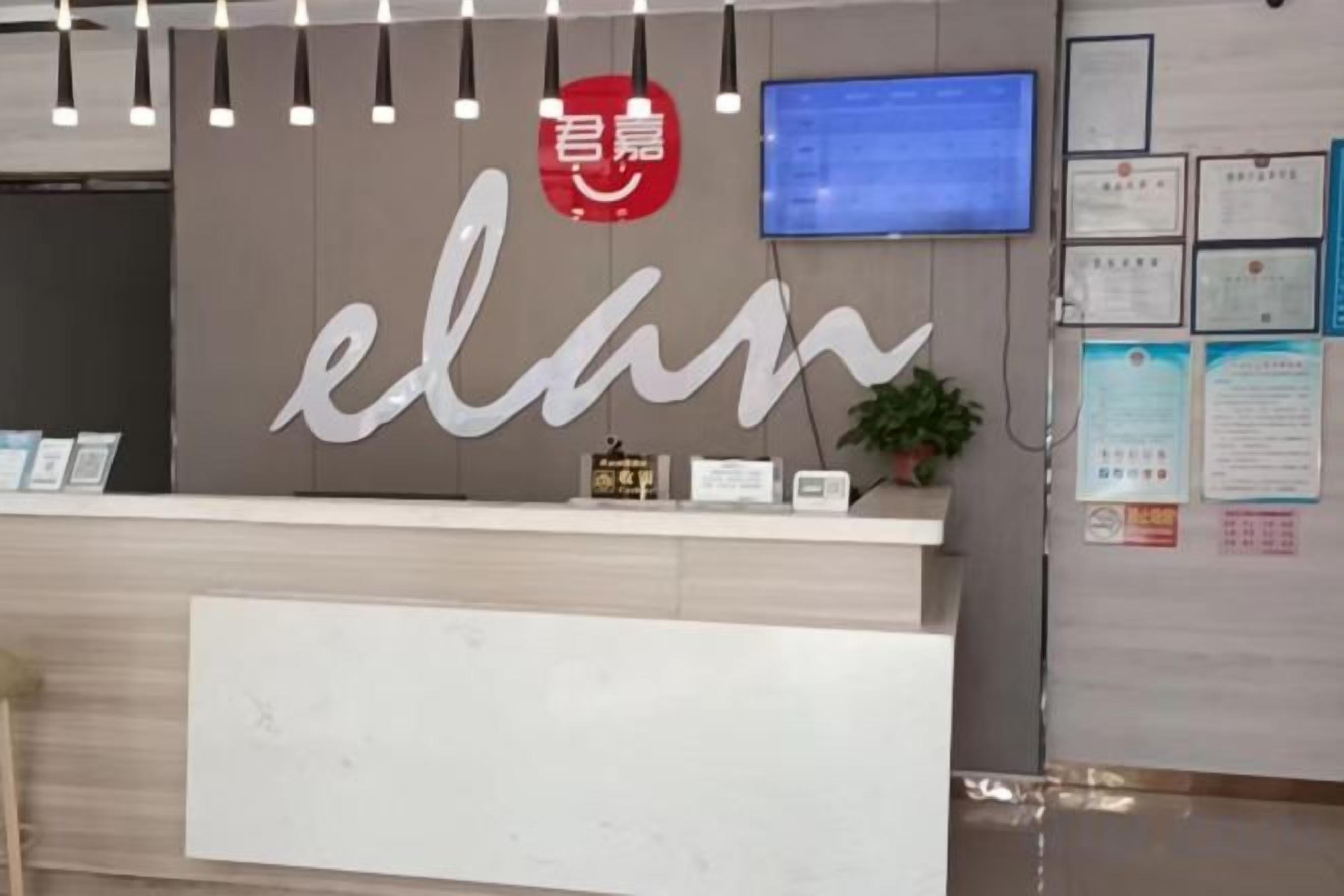 A reception desk with a sign that reads 'elan' and a red circular logo above it.