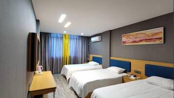 Een hotelkamer met twee bedden, een bureau, een stoel, een televisie en een schilderij aan de muur.