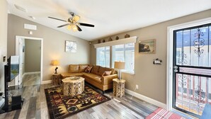 A living room with a brown leather sofa, patterned rug, and a ceiling fan. - #4-cnvnt 4B3B fits 8PPL, 15 mins walk to heavenly (South Lake Tahoe)