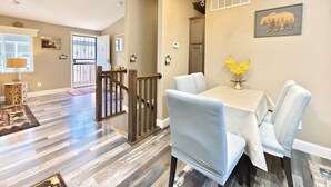 A dining area with a table and chairs, a chandelier, and a staircase leading to another room. - #4-cnvnt 4B3B fits 8PPL, 15 mins walk to heavenly (South Lake Tahoe)