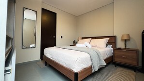 A modern bedroom with a wooden bed, a nightstand, a lamp, and a mirror. - APARTMENT NEAR PROVENZA BY HOOST 2410 (Medellín)