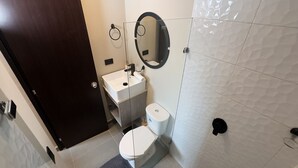 A modern bathroom with a toilet, sink, and mirror. - APARTMENT NEAR PROVENZA BY HOOST 2410 (Medellín)