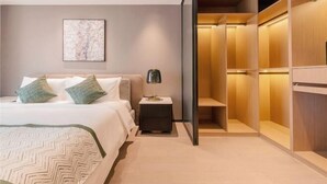 Un dormitorio moderno con cama, mesita de noche, lámpara y vestidor.