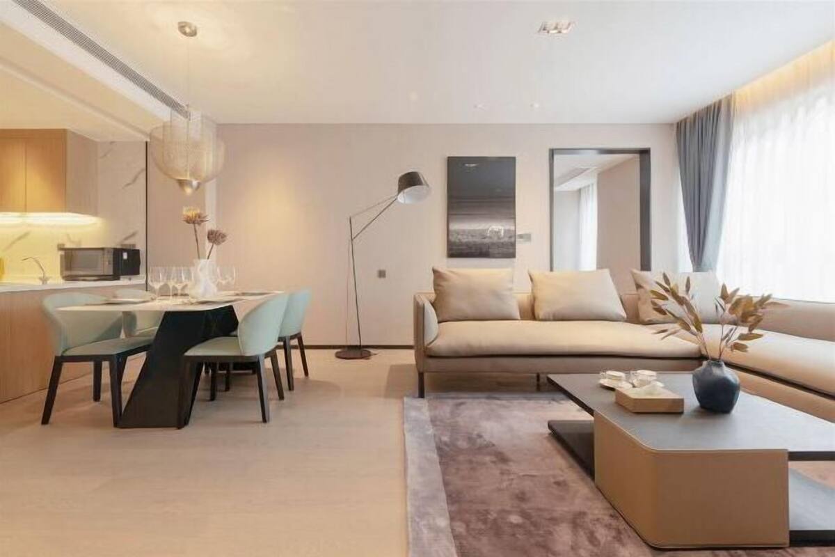 A modern living room with a sofa, coffee table, and dining area.