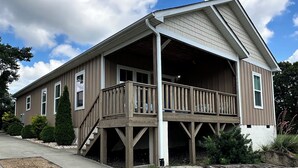 A two-story house with a covered porch and a staircase leading to the second floor.
