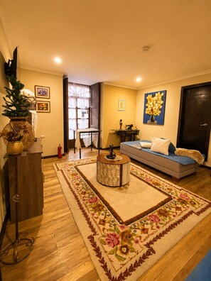 A living room with a sofa, a coffee table, a decorative vase, and a rug. - Melody Hotel (Cuenca)