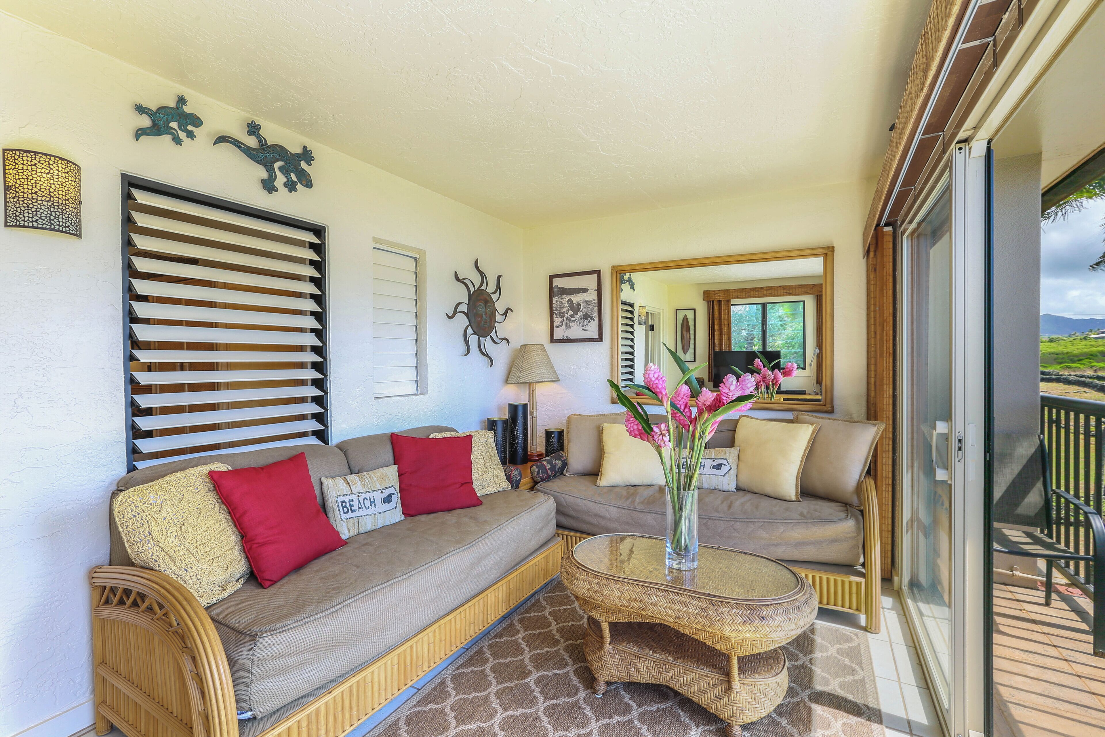 A cozy living area with a sofa, a coffee table, and a balcony with a view.