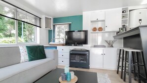 A modern kitchen with a TV, oven, and bar stools. - Gorgeous home in Merksplas (Merksplas)