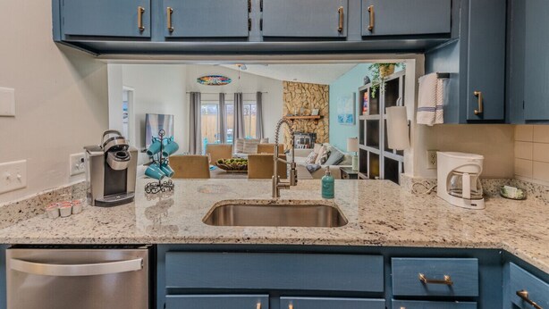 A modern kitchen with dark blue cabinets, a granite countertop, and stainless steel appliances. - Beach Retreat with Backyard Flair! w/Yard Games (Atlantic Beach)