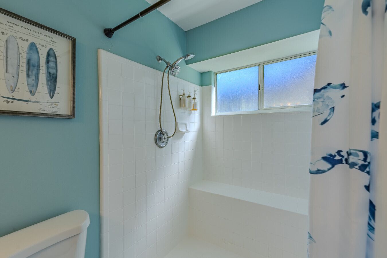 Une salle de bain avec une douche, des toilettes et une fenêtre en verre dépoli.