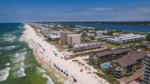 An aerial view of a coastal hotel area with beachfront properties, a sandy beach, and ocean views. - Sandpiper 7-C  ON THE BEACH - Heated Pool - Smart TVs (Gulf Shores)