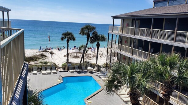 A pool area with a view of the beach and ocean. - Sandpiper 7-C  ON THE BEACH - Heated Pool - Smart TVs (Gulf Shores)