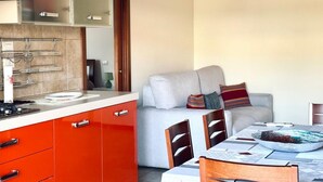 A compact living space with a kitchenette, a sofa, a dining table, and a chair. - SE123 - Marzocca, three-room apartment 300 meters from the sea (Marzocca)