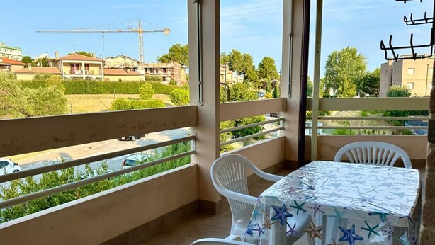 A balcony with a table and chairs, a view of a construction site, and a clear sky. - SE123 - Marzocca, three-room apartment 300 meters from the sea (Marzocca)