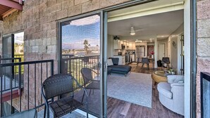 Un balcon spacieux avec une porte-fenêtre coulissante donnant sur une cuisine moderne et un salon.