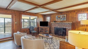 A cozy living room with wooden walls, a fireplace, a television, and comfortable seating. - Center Hill Couples Retreat Cabin: Lake View, Deck (Sparta)