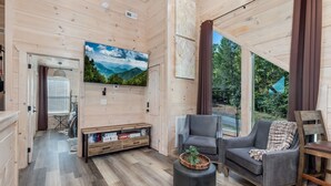 Arredamento in legno con televisione, divano e poltrona.