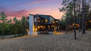 Una casa moderna de dos pisos con fachada de piedra, ventanas amplias y entrada de grava.