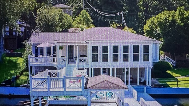 A waterfront building with a dock, a covered area, and a flag. - Lake house 35 from Auburn and Ft. Benning (Salem)