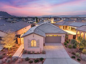 A residential area with houses featuring tiled roofs and a central driveway leading to a garage. - El Encanto: EV Charger, Pool, Spa & BBQ (La Quinta)
