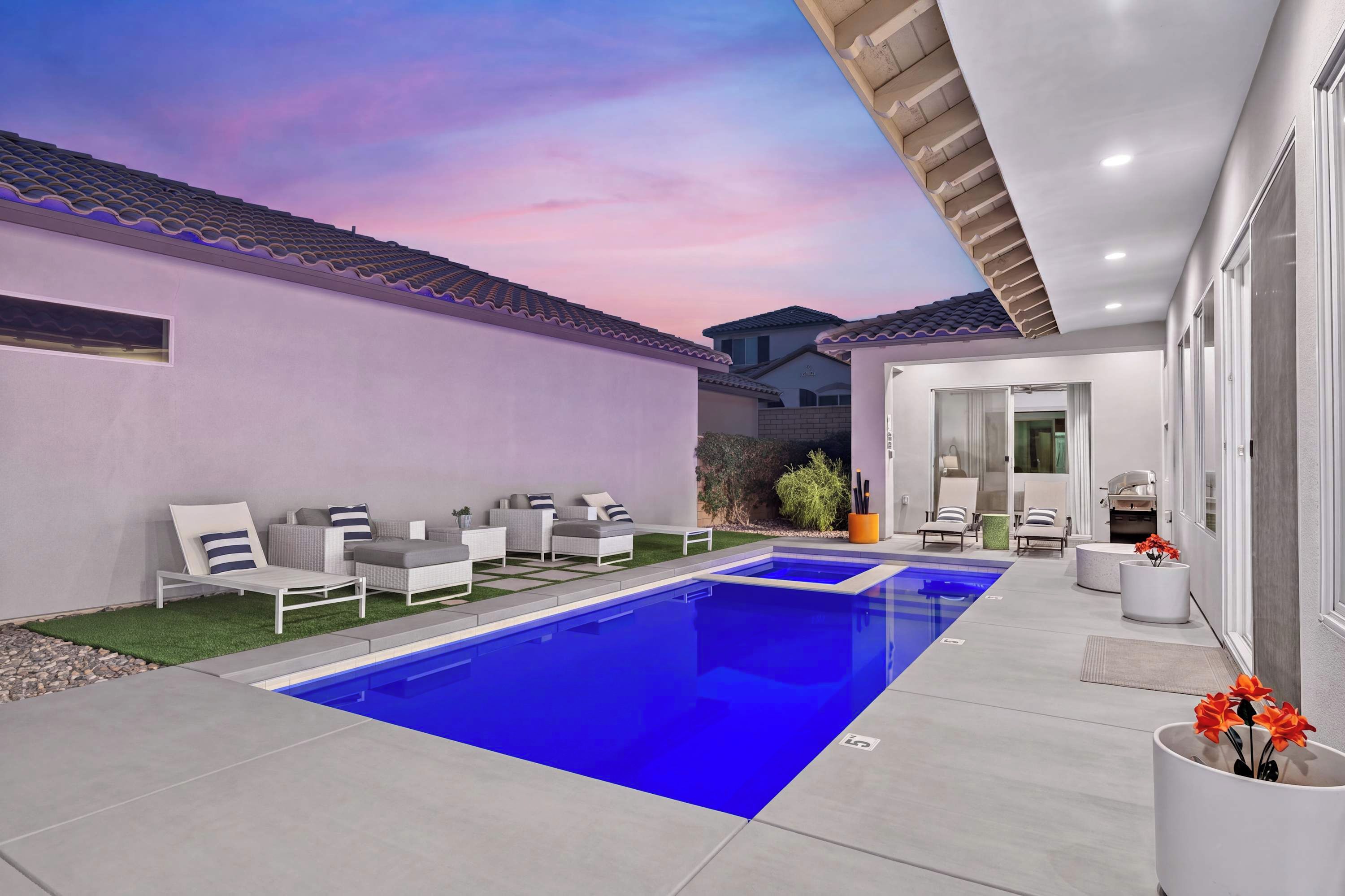 Ein moderner Poolbereich im Freien mit einem klaren, blauen Pool, umgeben von Liegestühlen und einer Terrasse.