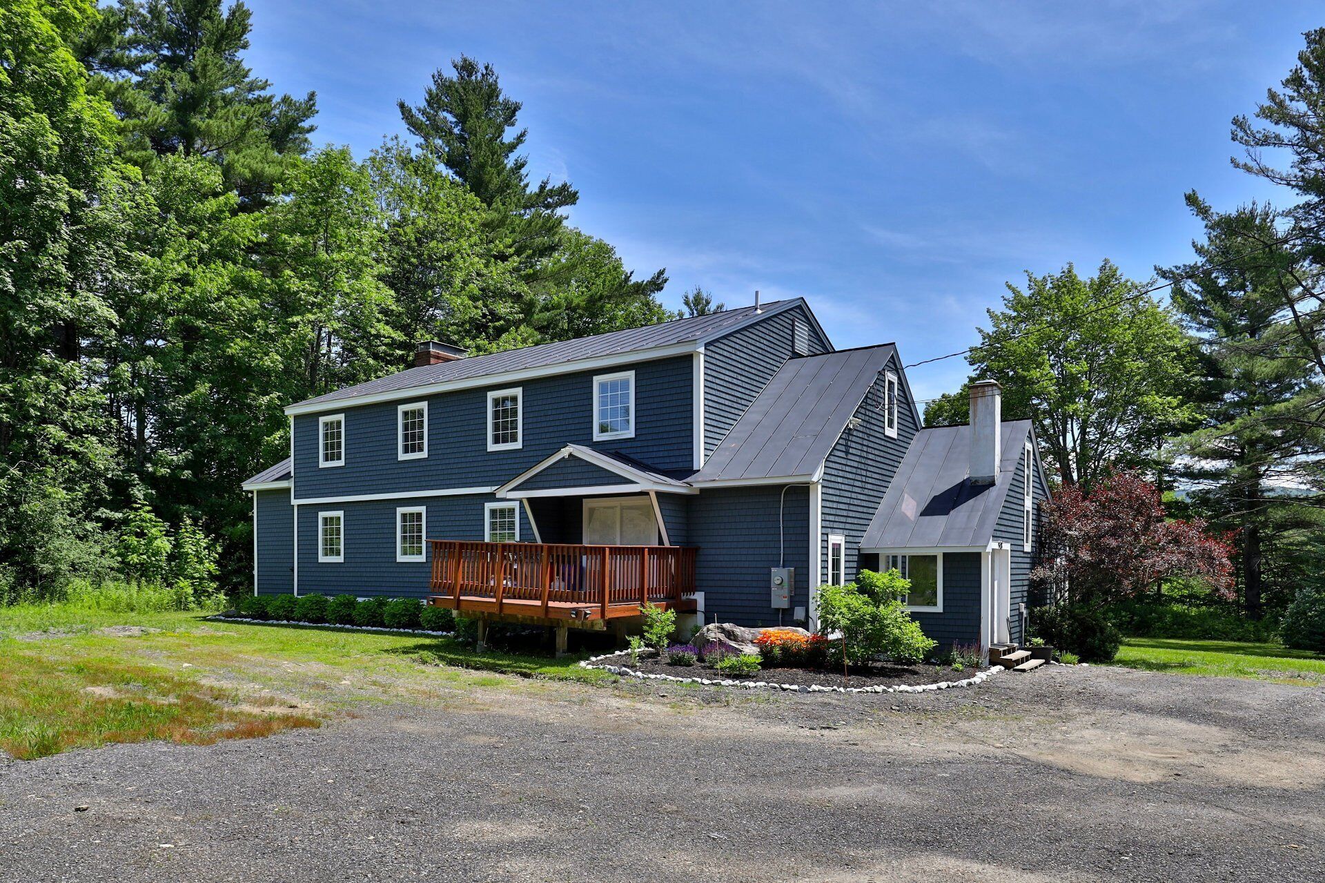 A two-story house with a front porch and a covered deck.