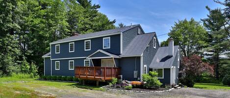 A two-story house with a front porch and a covered deck.
