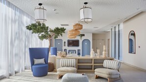 A modern living room with a blue armchair, a round ottoman, and a wooden coffee table.