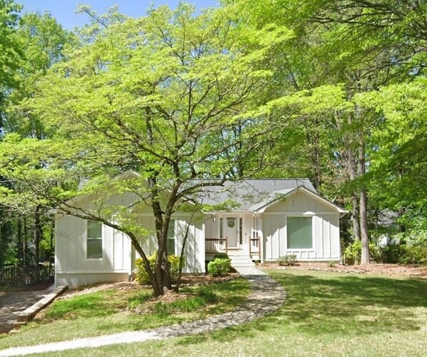A single-story house with a front porch, a small front yard, and a pathway leading to the entrance.