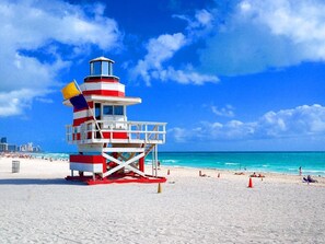 A beach with a lifeguard tower, sandy beach, and ocean. - Serenity Haven 2BR|1BA | Spacious | Free Parking (Miami)