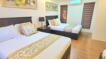 A hotel room with two beds, a wooden ceiling, and decorative wall art.
