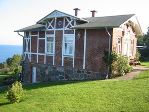 Ein zweistöckiges Backsteinhaus mit weiß verziertem Rahmen, einem Steinfundament und einem Schornstein.